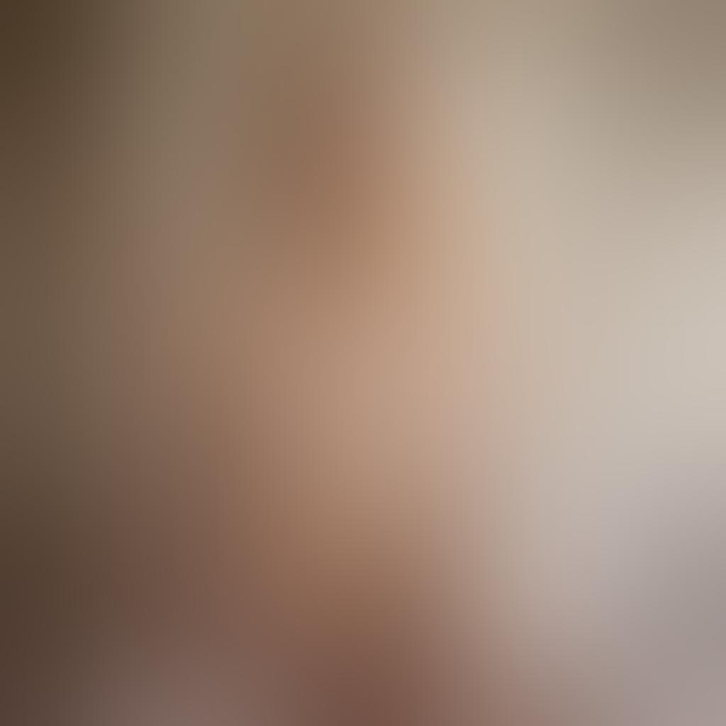 A soft-focus portrait capturing the essence of a blonde model in a tasteful nude pose, surrounded by flowing silk fabrics and soft light that accentuates her natural beauty. The background features delicate floral patterns that evoke sensuality and elegance, while the lighting creates a warm, inviting glow. The image should embody grace and intimacy, highlighting the artistic aspects of nude photography. super-realistic. vibrant colors. soft focus.